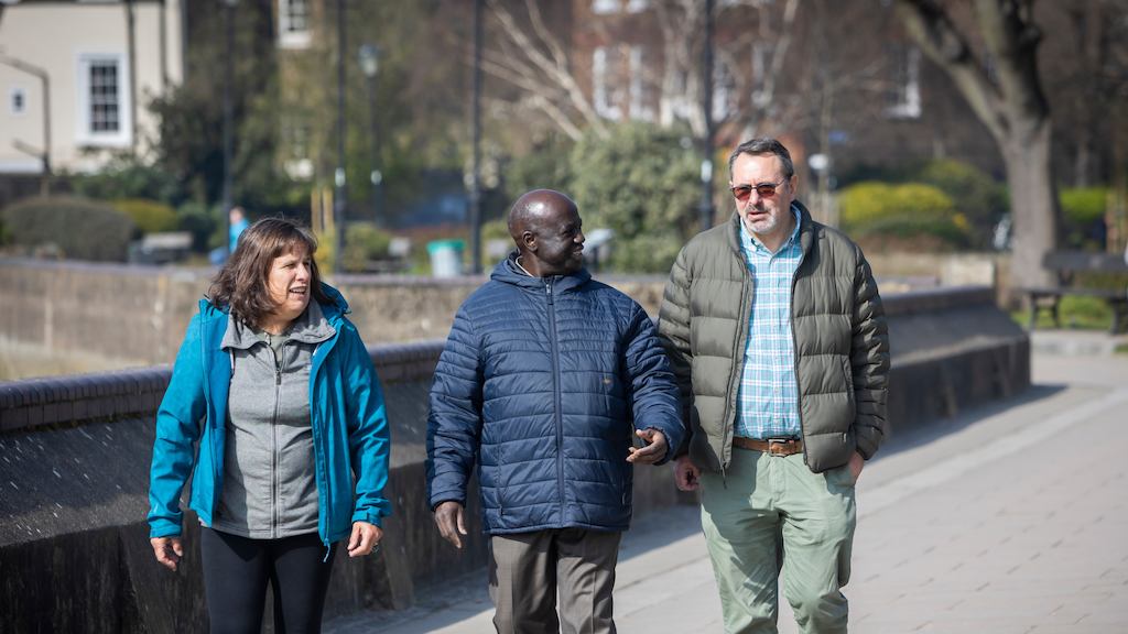 A group of older people walking by a canal